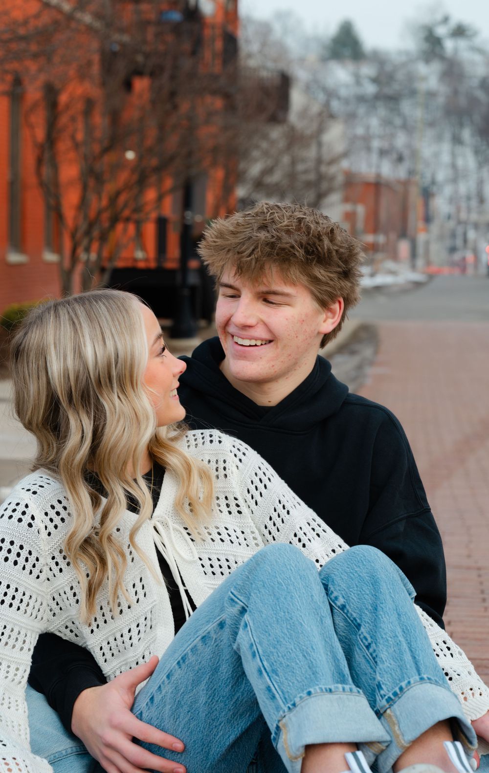 Couple downtown grand rapids sitting on ground holding each other