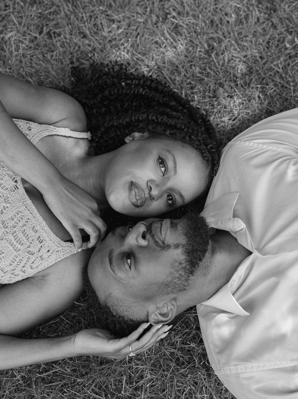 Couple laying on ground in black and white