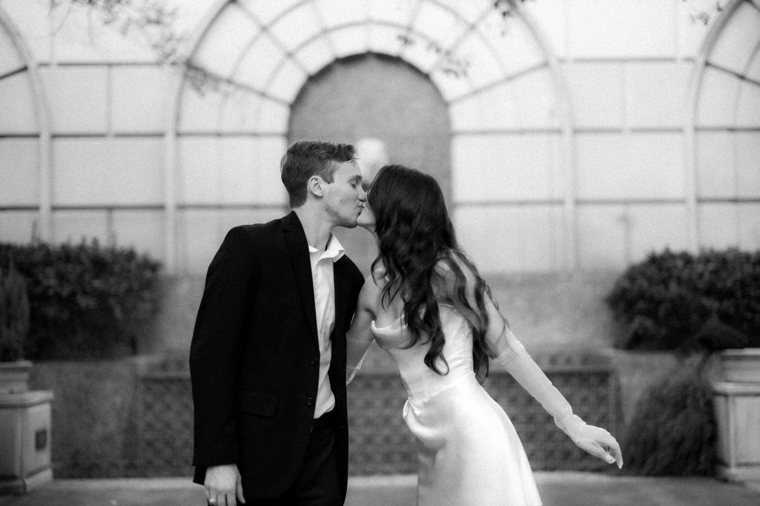 Black and white images captured under an elegant arched architectural structure.