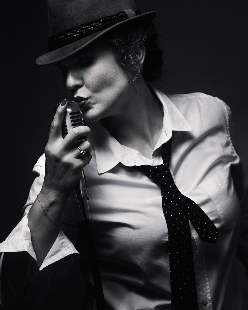 Noir-inspired portrait of a performer in fedora and tie. A moody, gender-bent classic from the Postmodern Lightbox series.