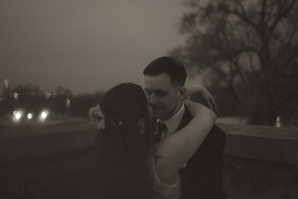A moody sunset silhouette creates a romantic atmosphere at an outdoor wedding.