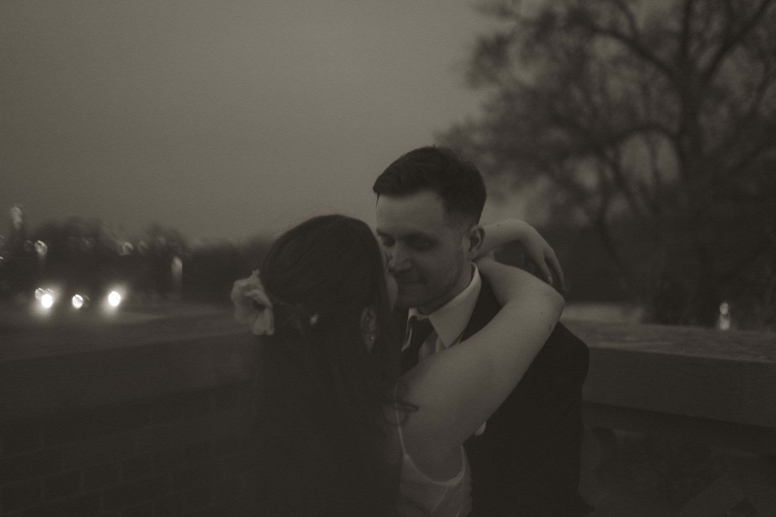 A moody sunset silhouette creates a romantic atmosphere at an outdoor wedding.