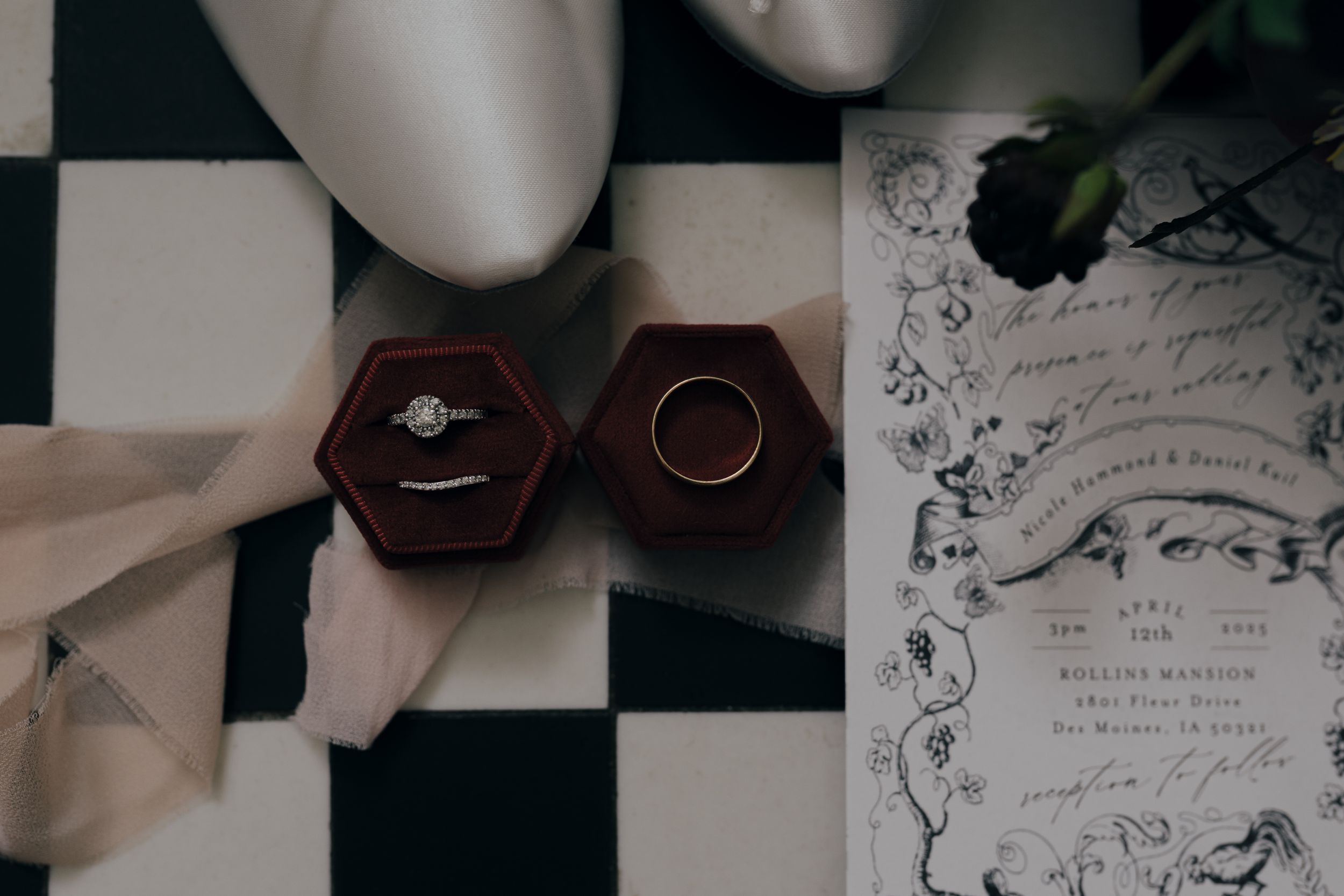 Wedding rings in wooden boxes displayed on a black and white checkered surface.