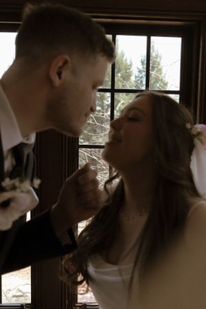 Intimate wedding moment captured in silhouette against window light.