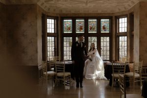 Panoramic view of wedding ceremony space with stained glass windows and natural light.