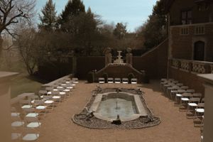 Aerial view of outdoor wedding venue with white chairs arranged in circular pattern.