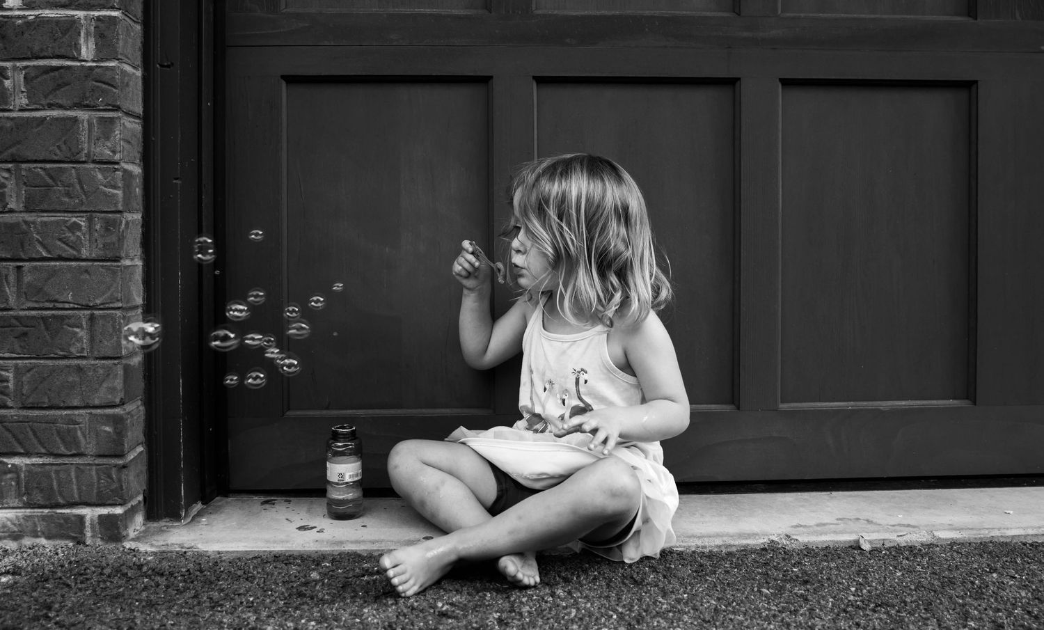Photo of a girl blowing bubbles during a family session at home