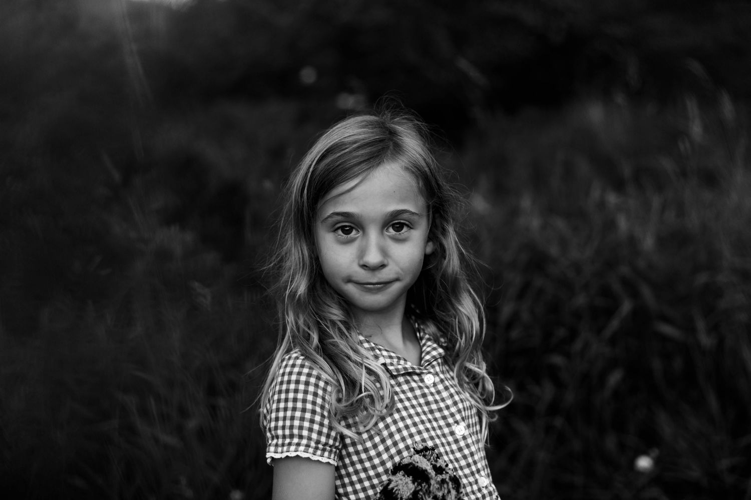 Black and white photo of a young girl looking straight at the camera.