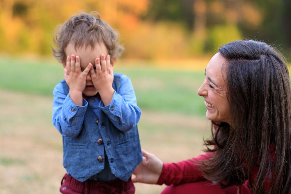 Candid outdoor autumn photo showing joyful interaction and laughter.