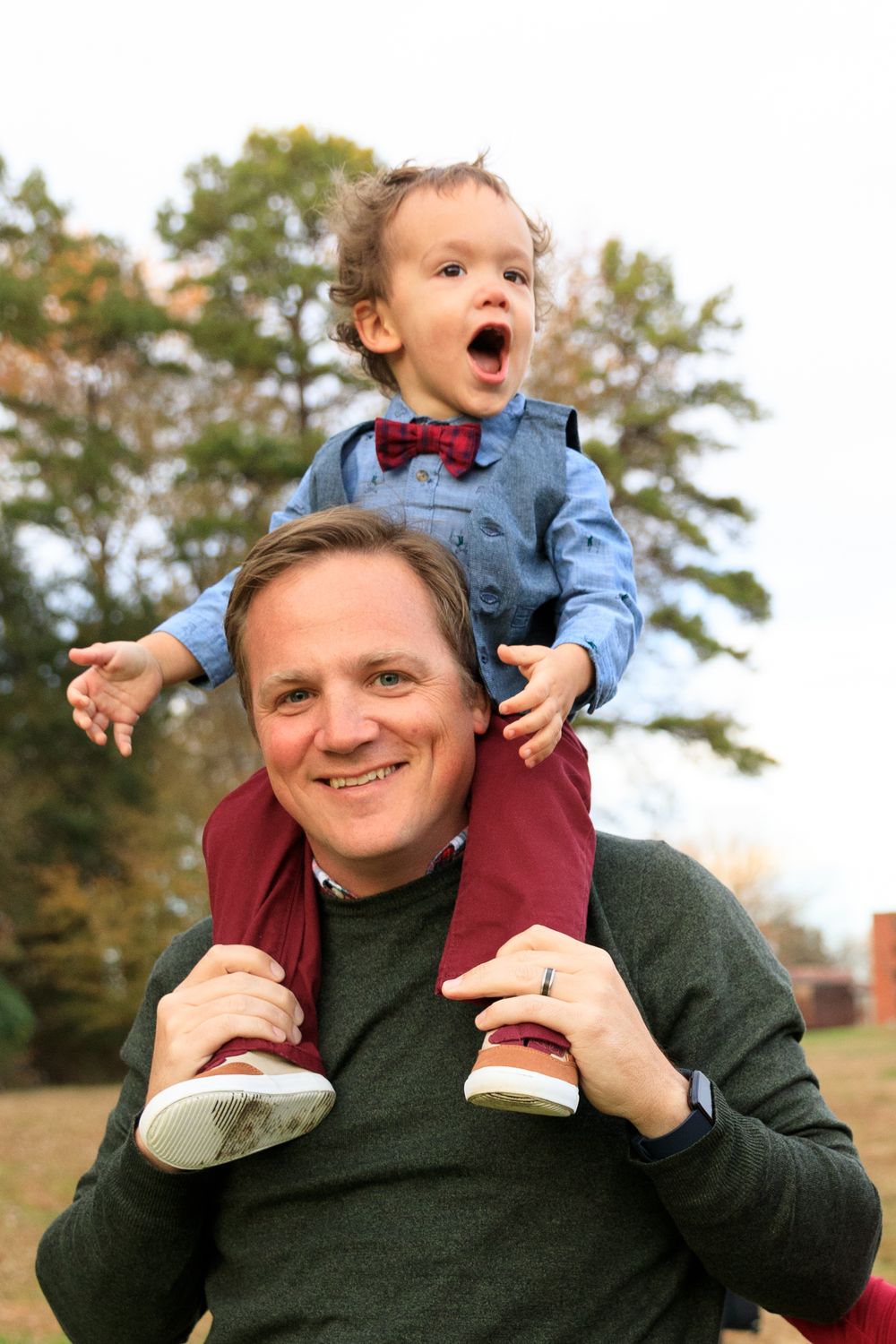Playful autumn family moment captured outdoors with expressions of joy.