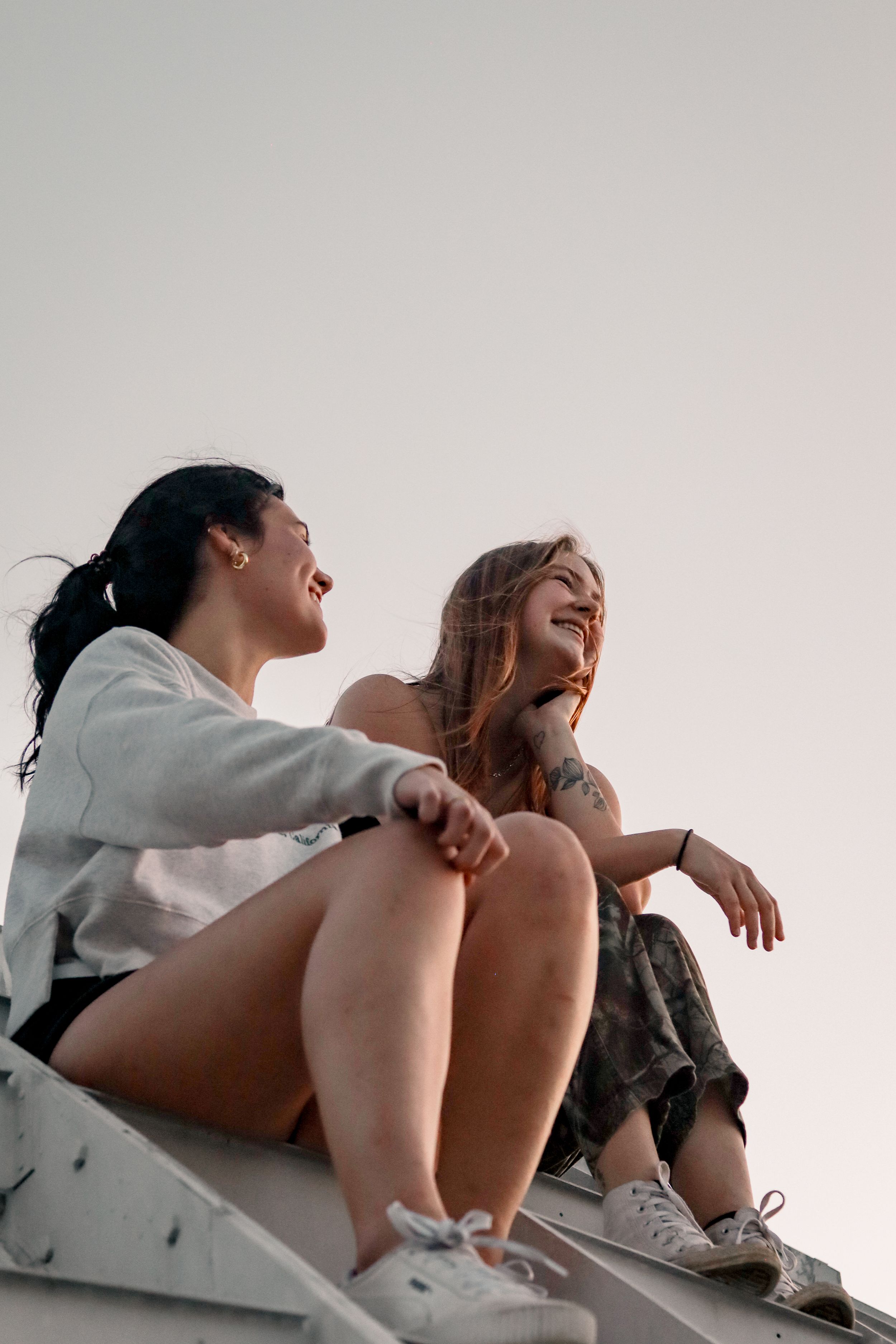 Two people sitting casually together laughing and enjoying a relaxed moment.