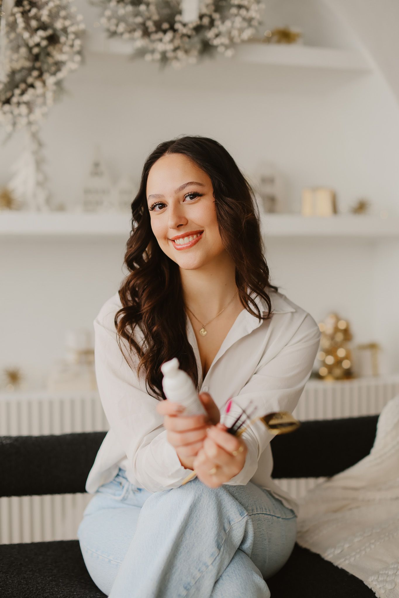 Beauty professional showcasing lash products in a bright, modern studio setting.