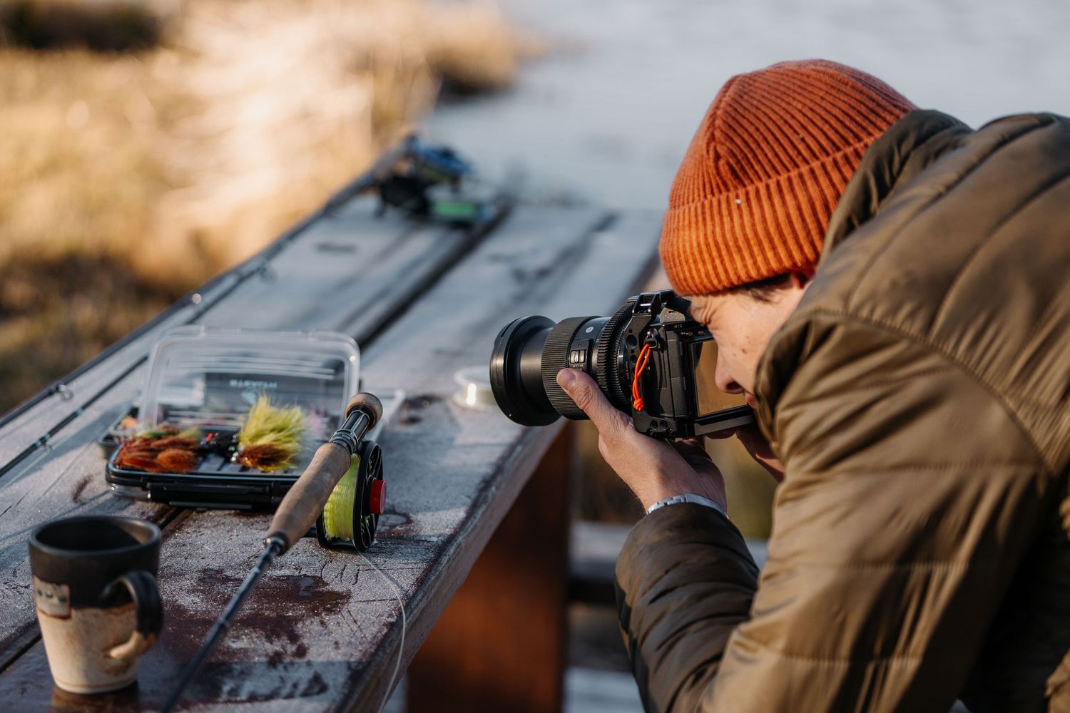 Fishing equipment and gear laid out on wooden surface.
