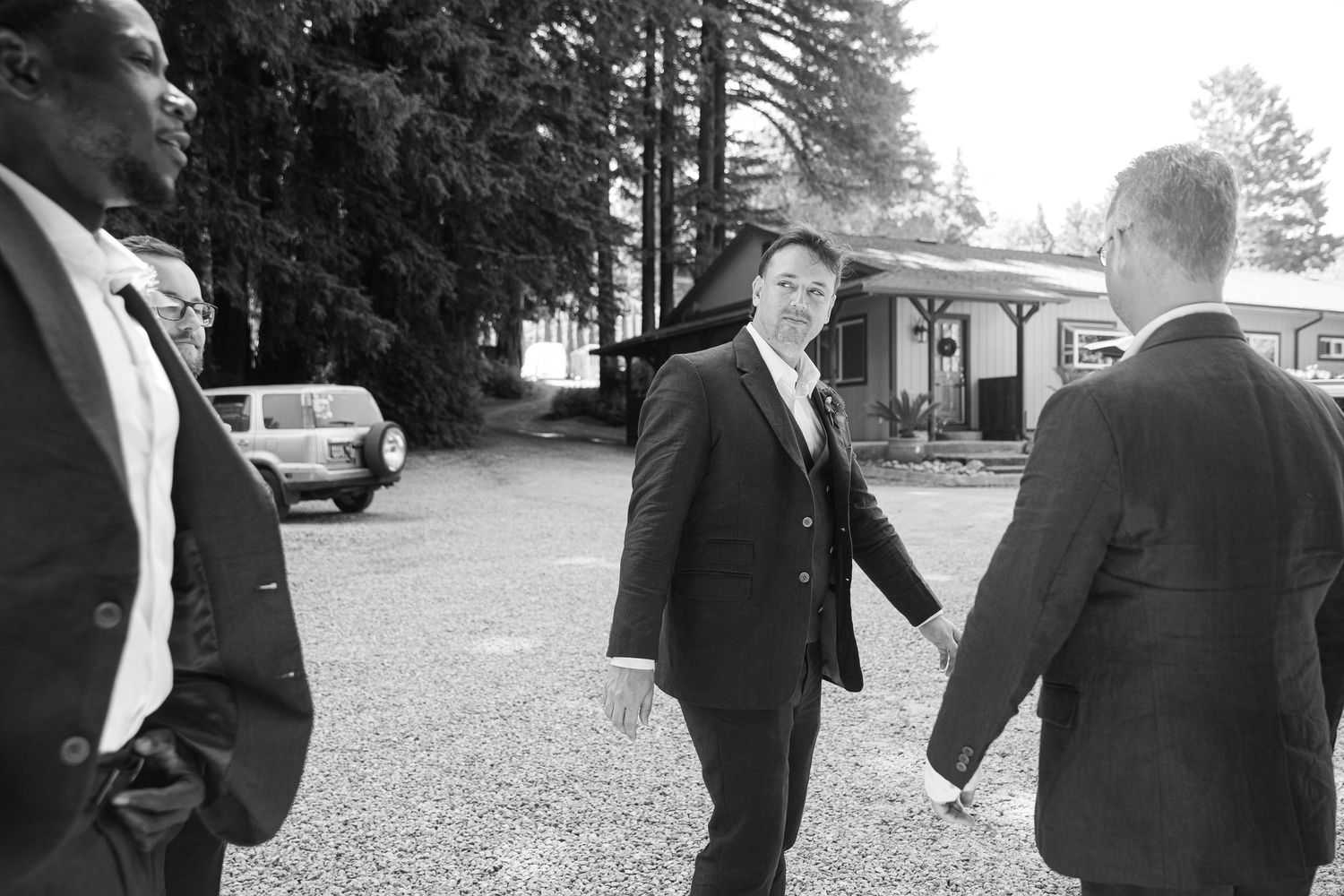 People in formal attire walking together at an outdoor event on a gravel path.