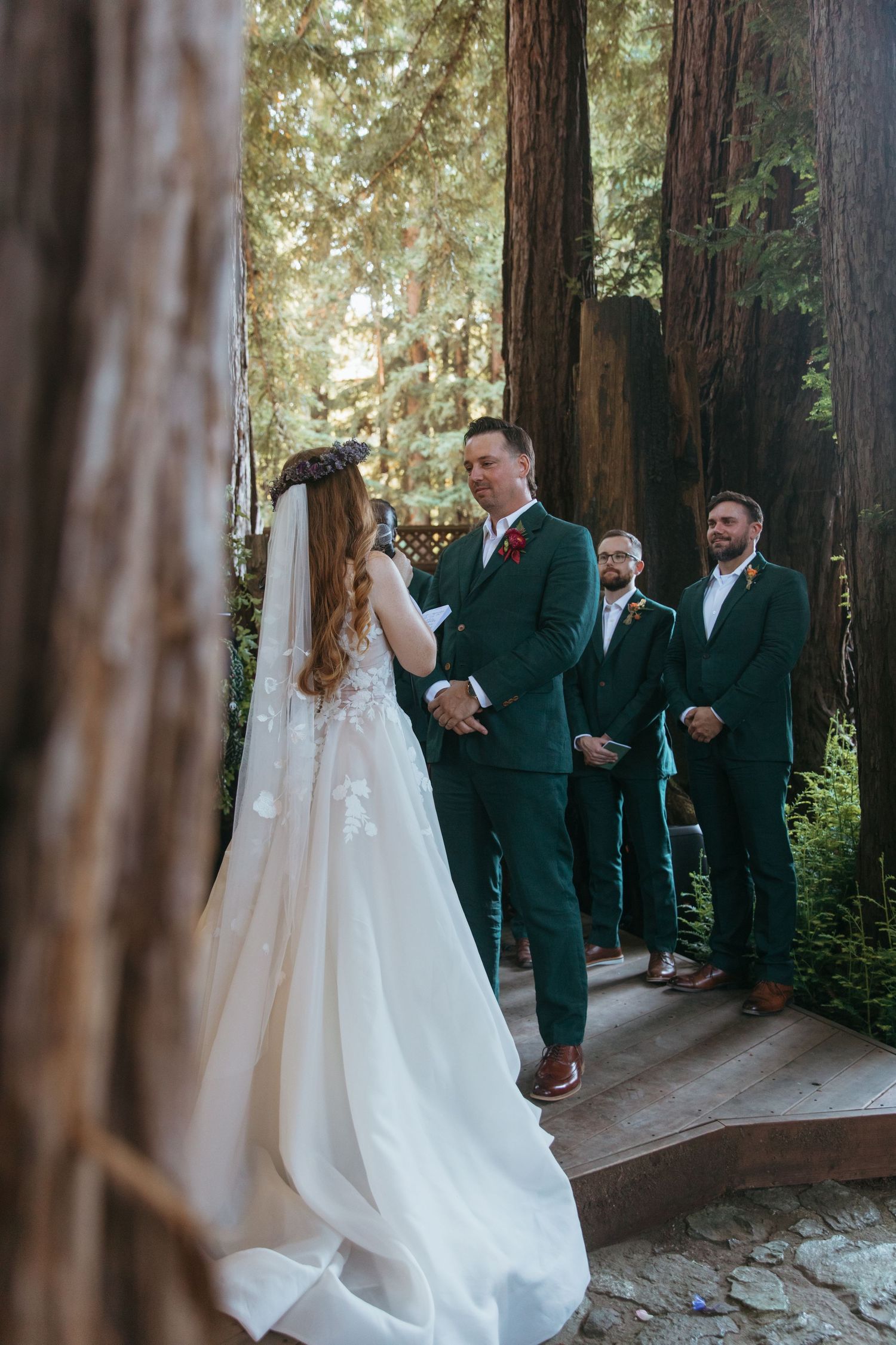 Wedding party stands together in a redwood forest setting during an outdoor ceremony.