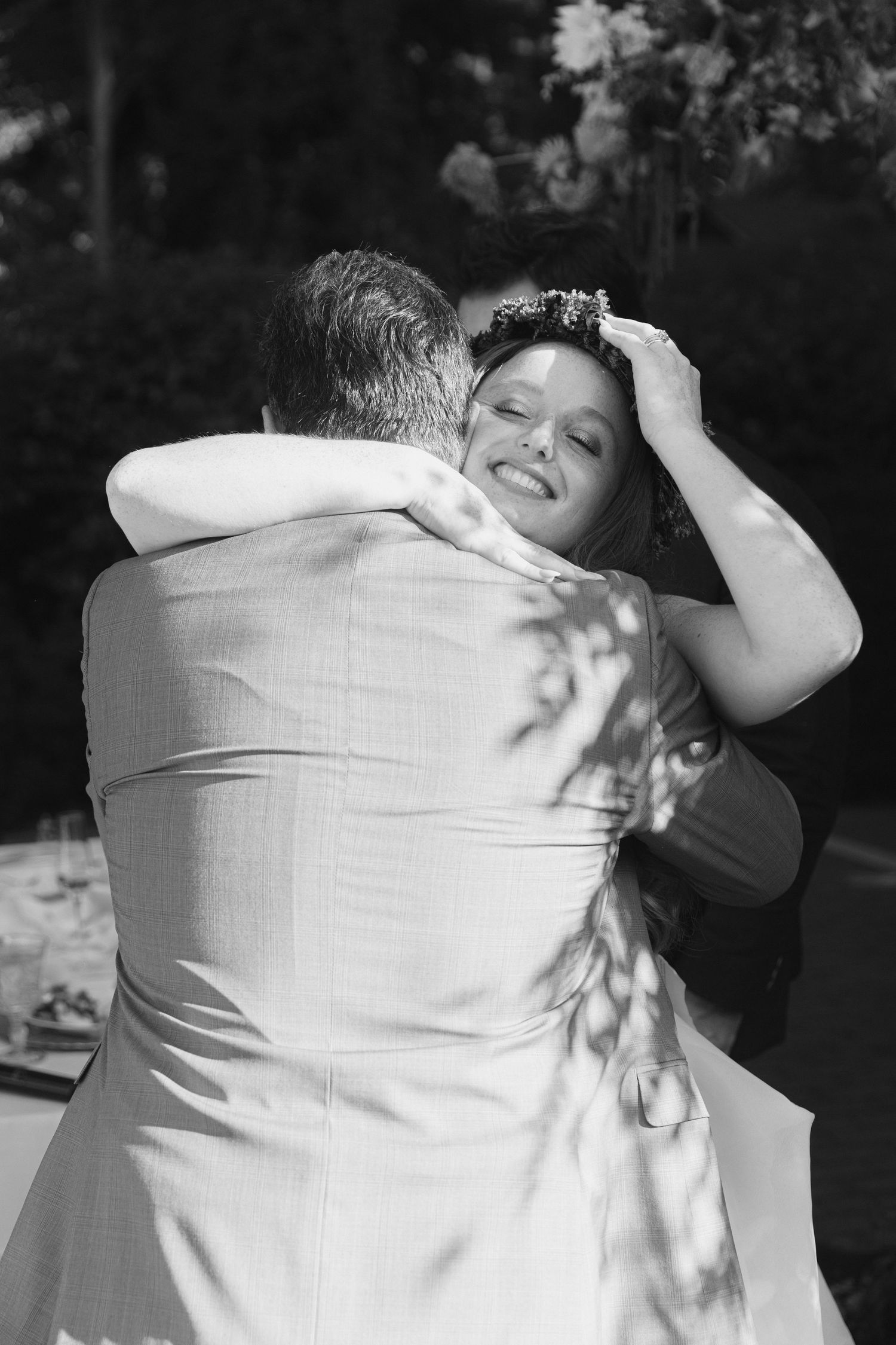 Black and white photos of guests dancing and embracing at an outdoor celebration.