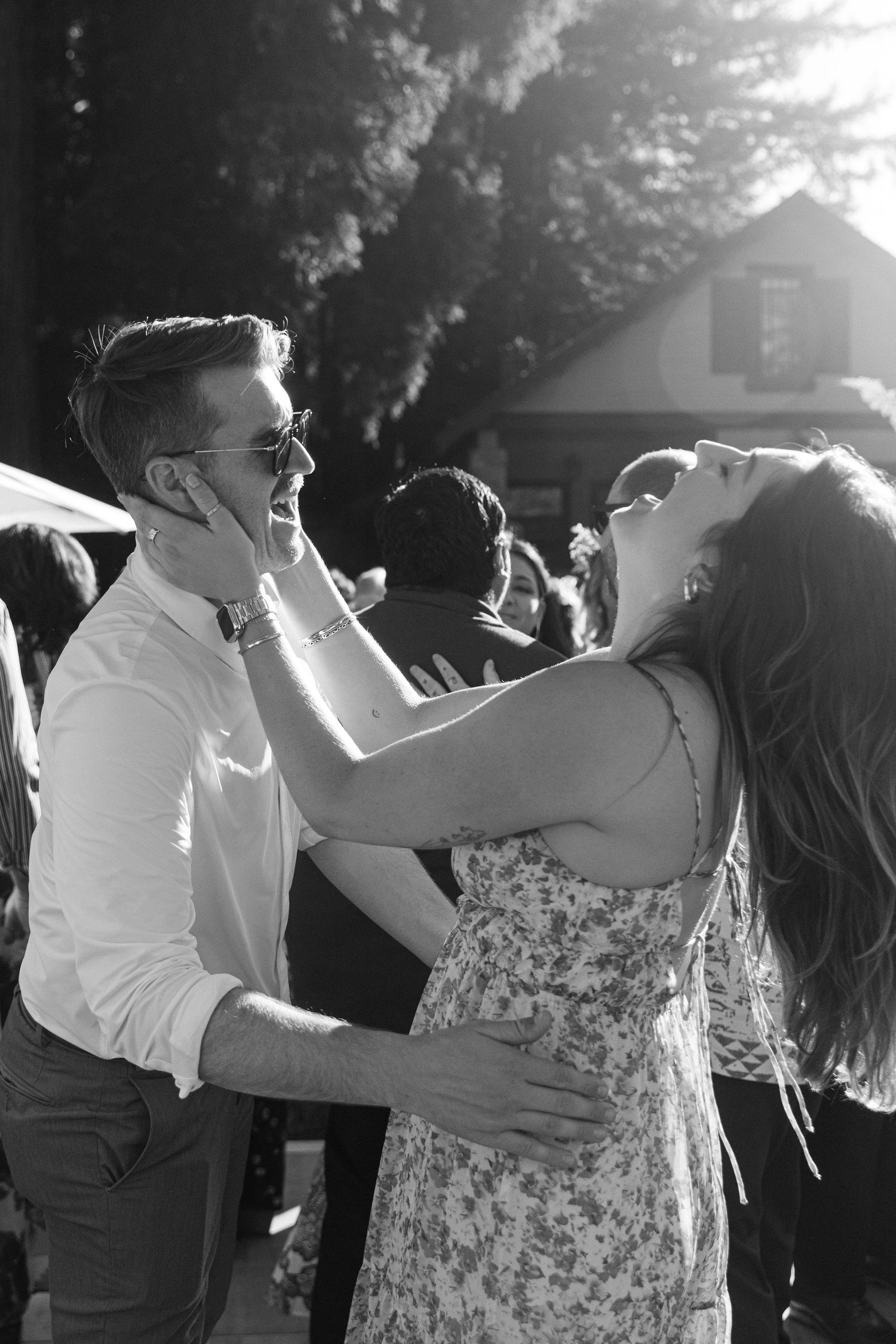 Black and white candid shots of wedding guests dancing together at an outdoor reception.