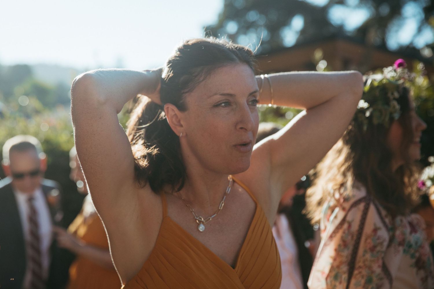 Wedding reception dance party with guests celebrating outdoors on a sunny day.