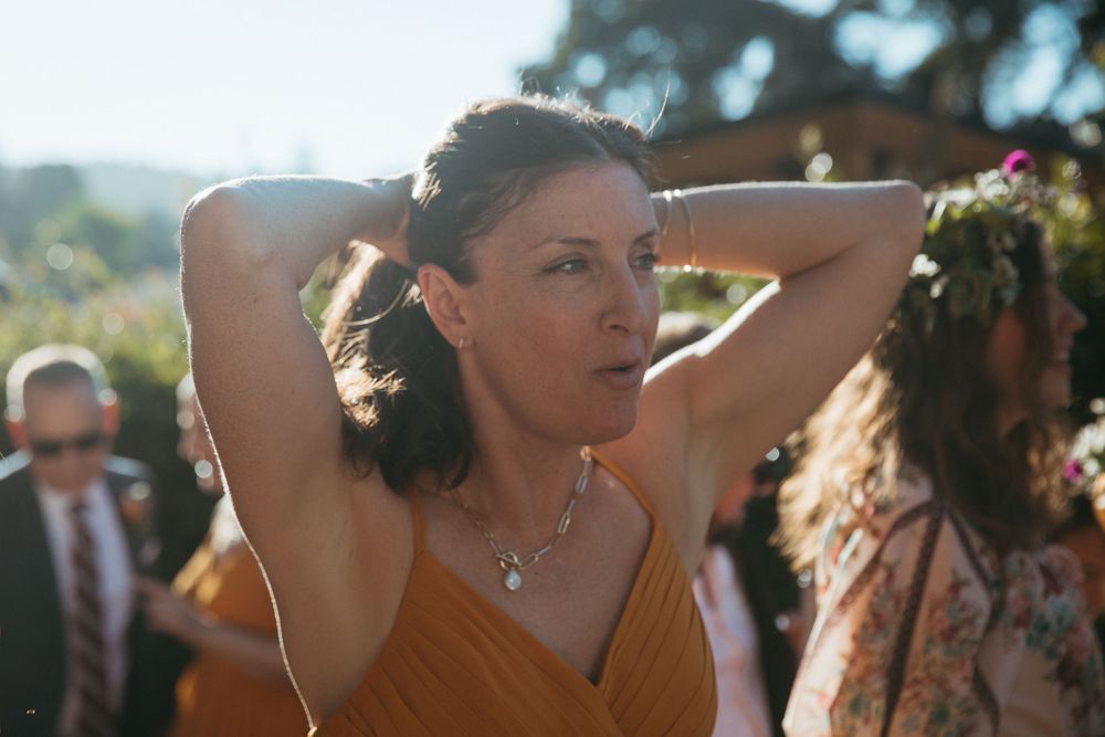 Wedding reception dance party with guests celebrating outdoors on a sunny day.