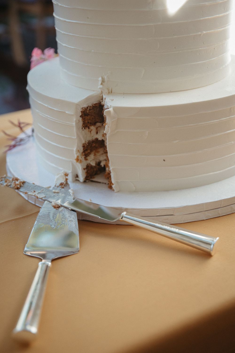 Close-up sequence showing a white wedding cake being cut with a silver serving knife.