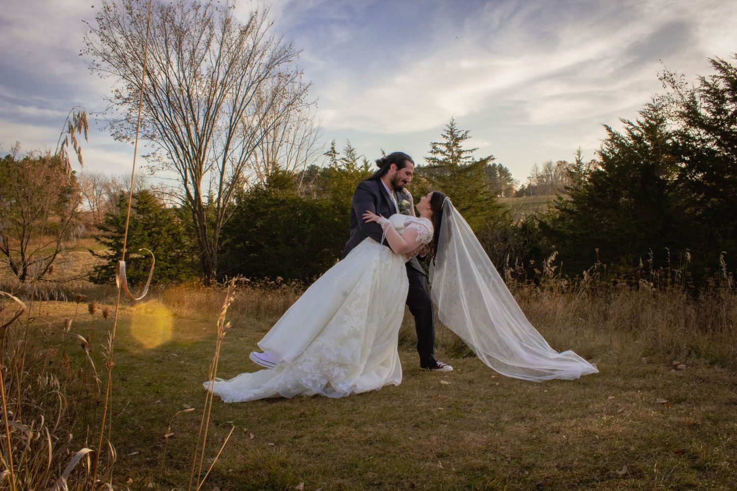 Dramatic wedding portraits in a field during golden hour.