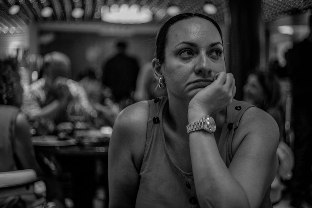 Black and white portrait in a dimly lit restaurant setting.