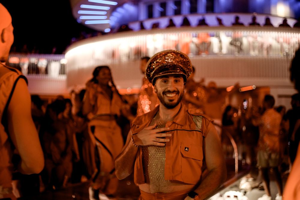 Nighttime festival scene with colorful lights and crowd silhouettes.