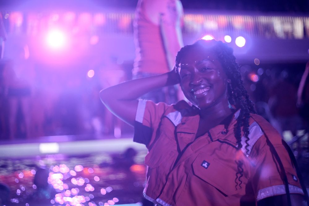Someone enjoying a moment at a nightclub under pink and purple lights.