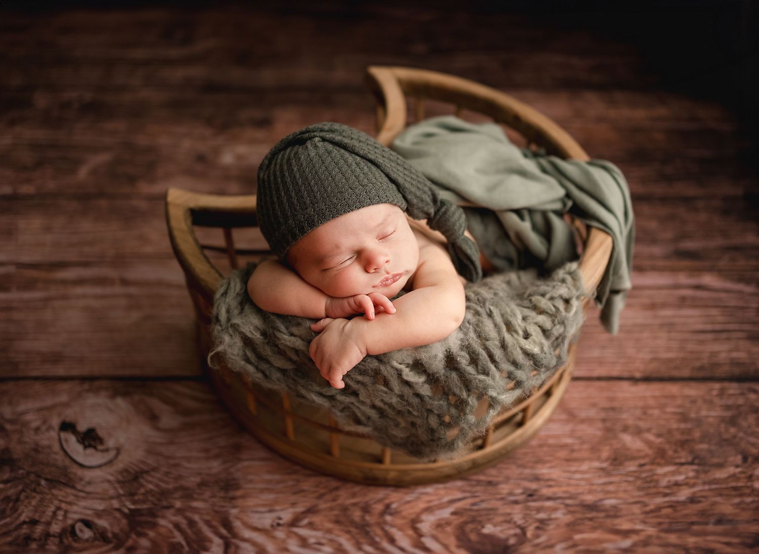 baby boy wrapped in green in moon basket during session with Raleigh Newborn Photographer