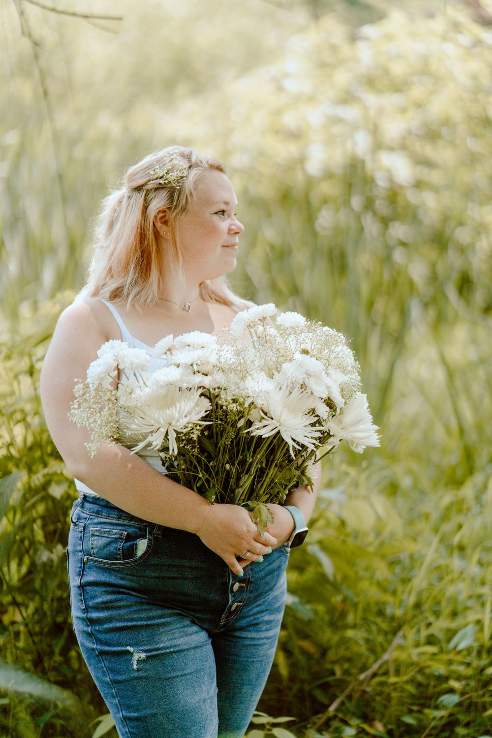 Sunlit nature portrait with white flowers and casual summer attire.