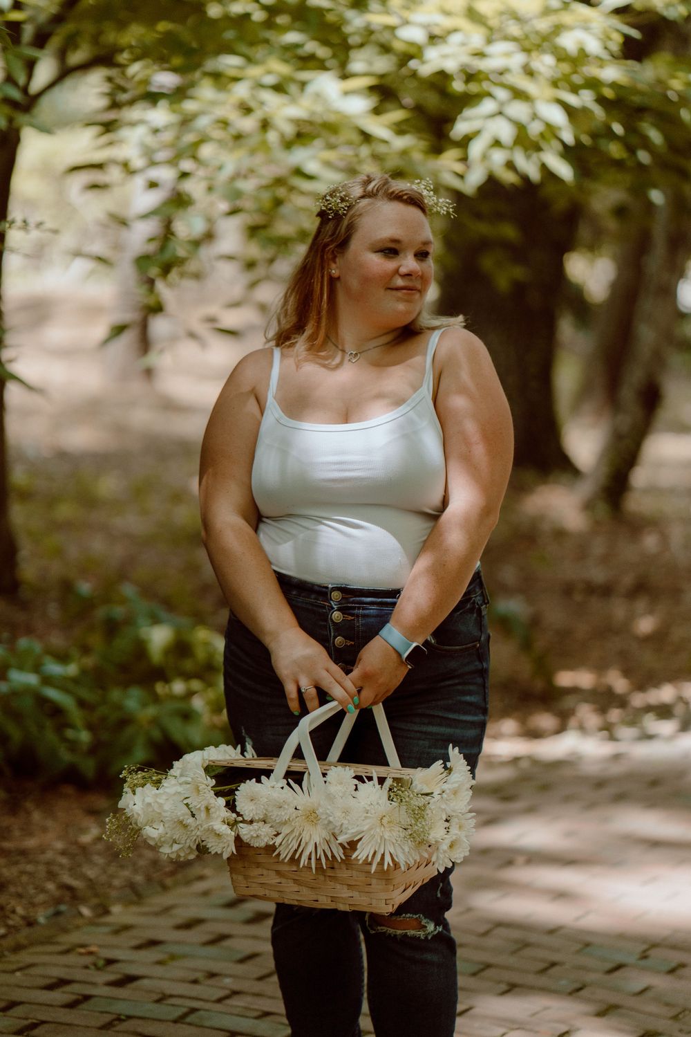 Summer portrait with white flowers and a woven basket in a shaded garden path.