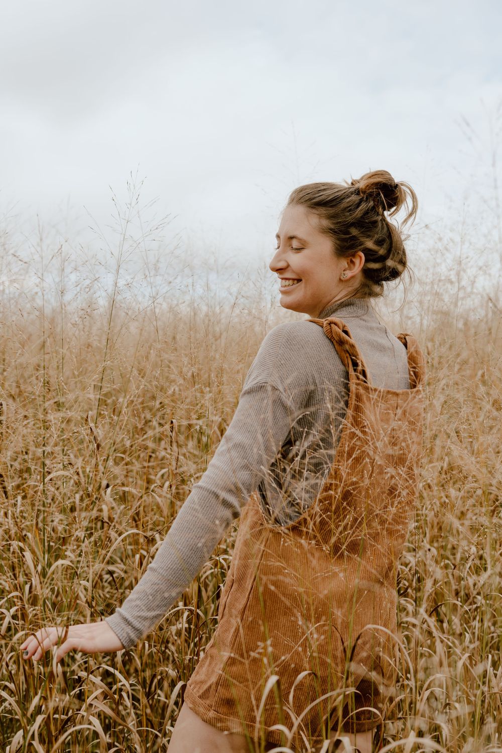 Candid moment of joy captured in sepia tones among tall grass.