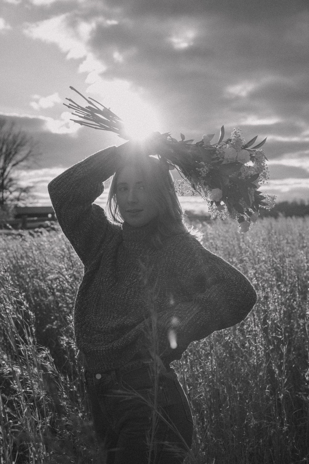 Black and white portrait silhouette against dramatic sky in tall grass field.