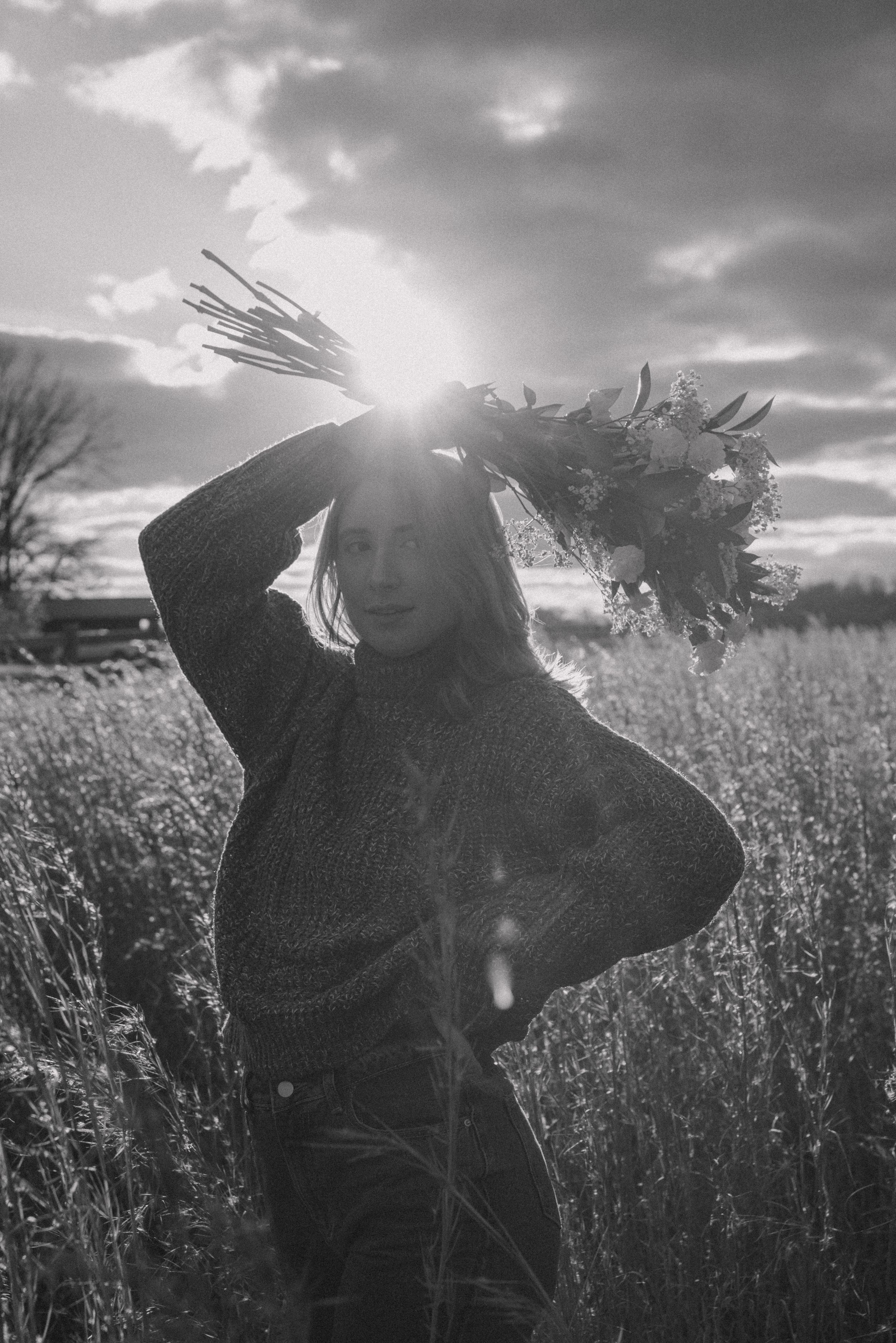 Black and white portrait silhouette against dramatic sky in tall grass field.
