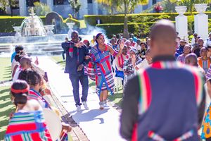 Crowd gathered outdoors wearing colorful traditional attire at a cultural celebration.