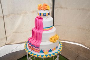 A modern wedding cake decorated with pink cascading details and tribal-inspired patterns.