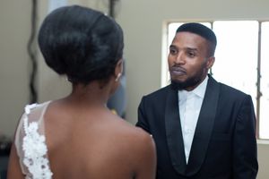 An intimate wedding moment captured between two formal-dressed individuals.