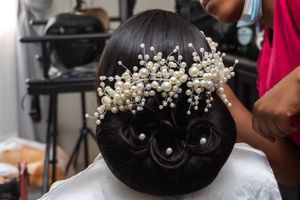 An elegant bridal updo hairstyle decorated with pearl hair accessories in a classic bun style.