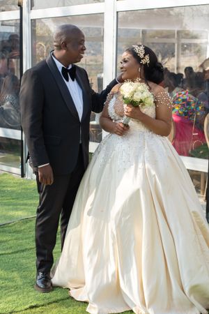 Newlyweds share intimate moment outdoors during wedding celebration.