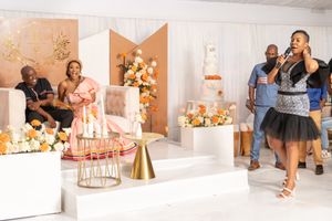 Wedding reception venue decorated with peach and orange floral arrangements.