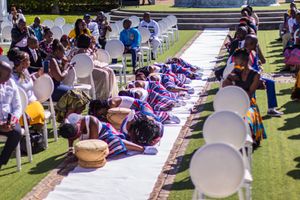 Traditional African celebration with drummers and performers on a sunny lawn.