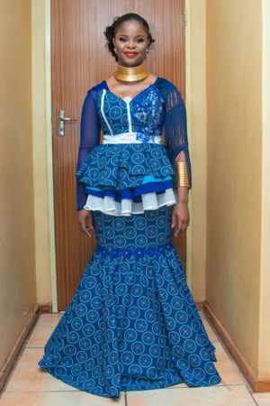 Full length view of elegant blue patterned mermaid dress with layered peplum detail.