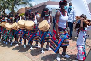 Traditional African dancers in colorful attire performing at outdoor event.