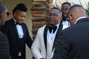 Group of men in formal tuxedos having a discussion before wedding ceremony.