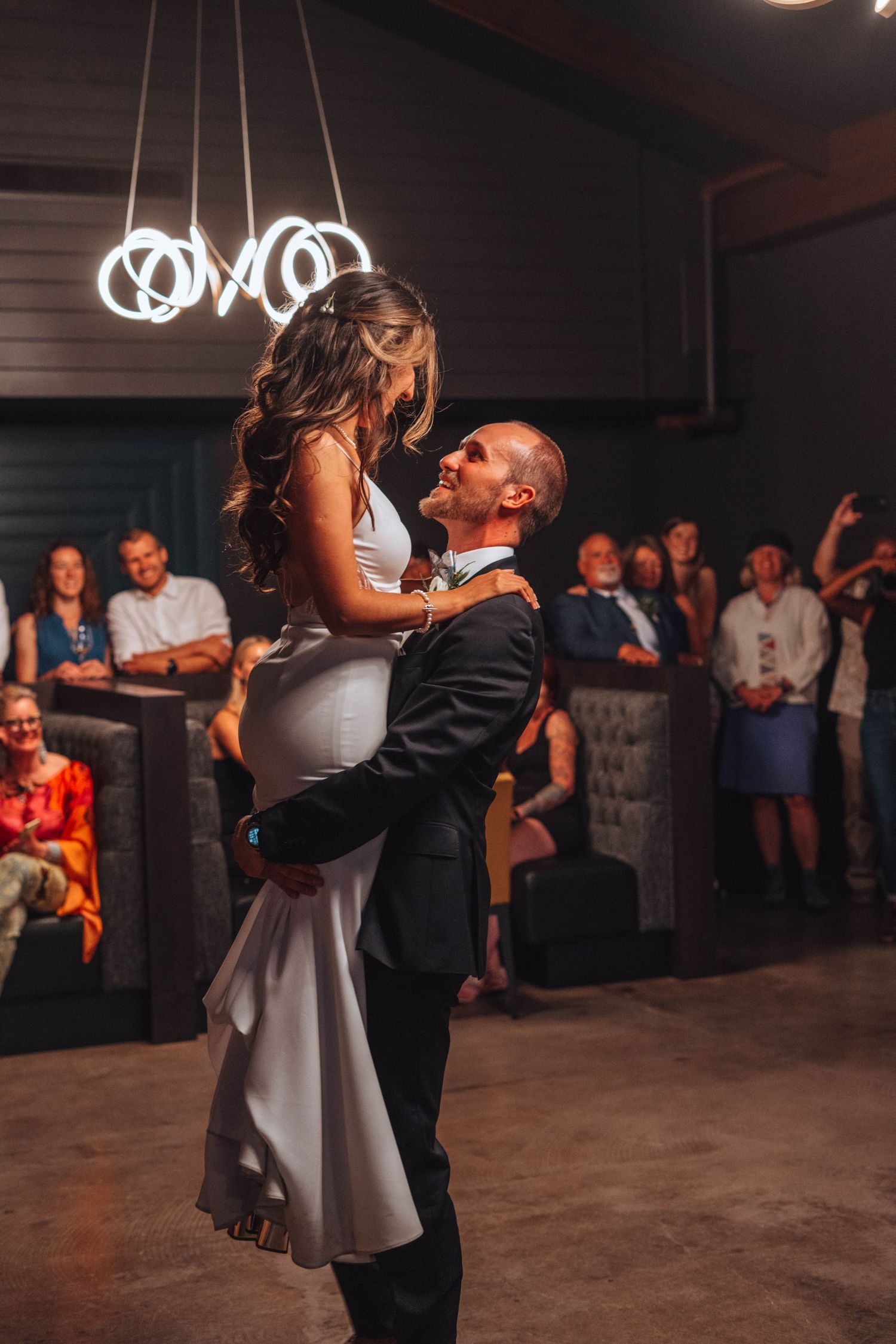 Groom lifting the bride in the air during their romantic first dance. Calgary wedding.