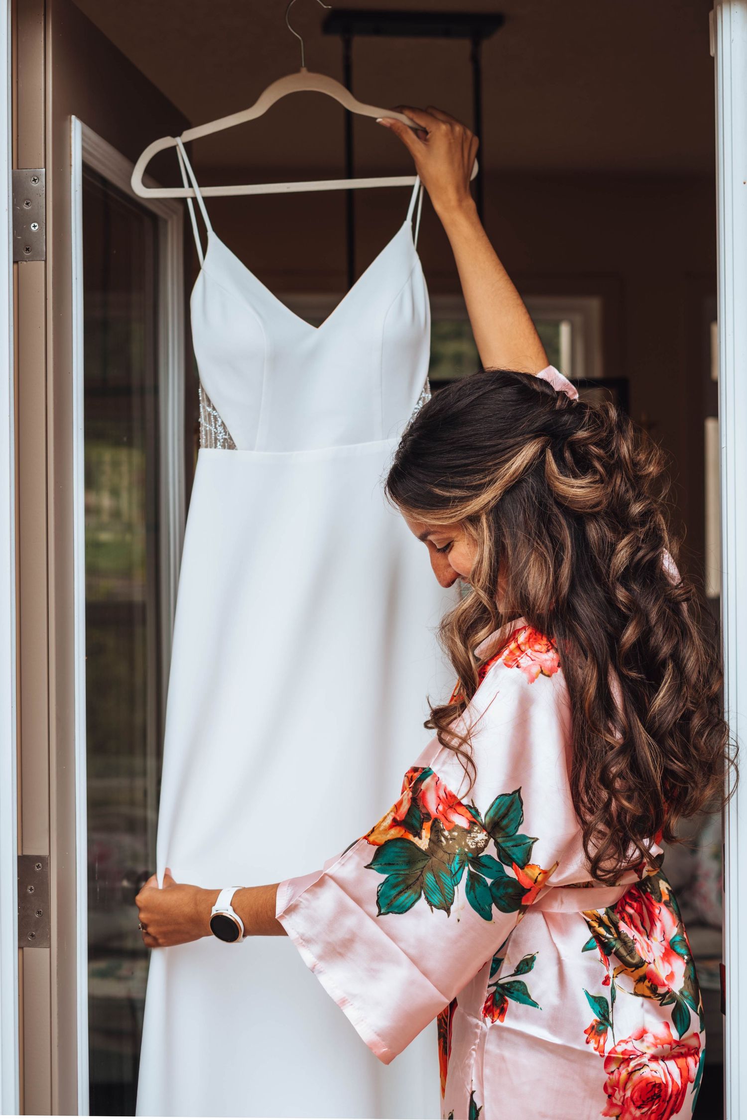 The bride admires her simple and elegant wedding dress. Calgary wedding.