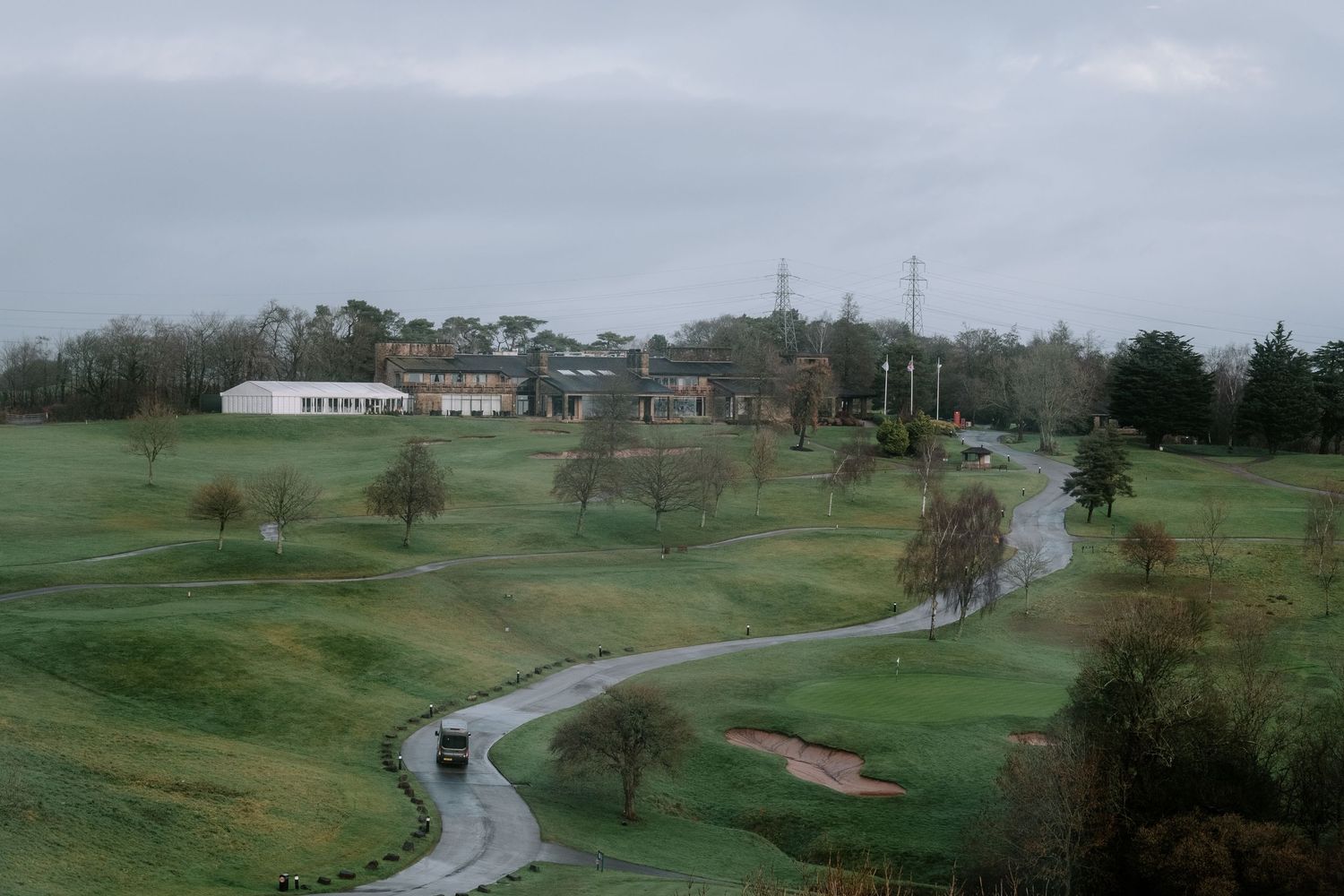 Aerial view of a rolling green golf course with winding paths.