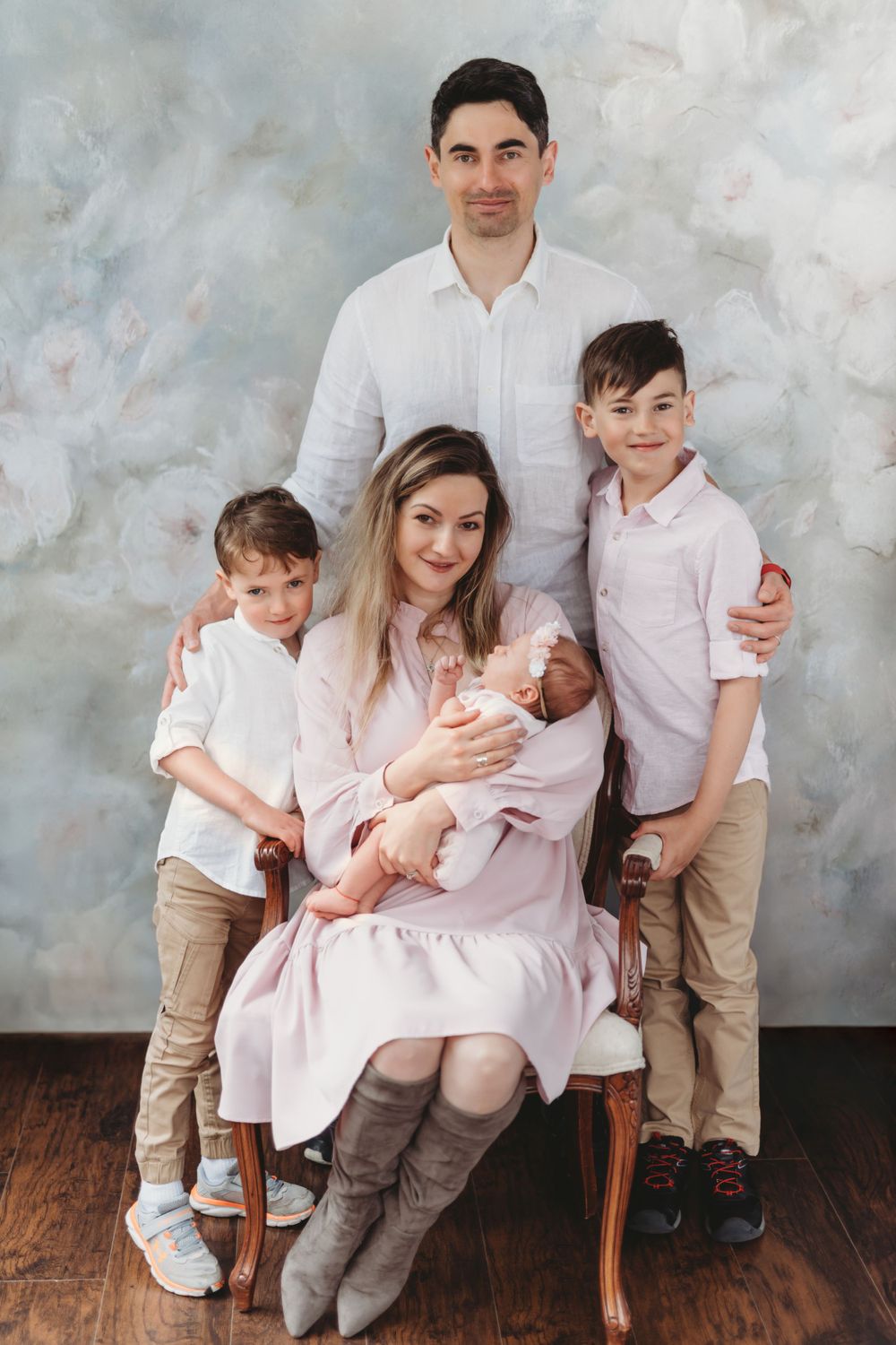 Studio family portrait with light background showing parents and three children in coordinating outfits. Bellevue studio, WA