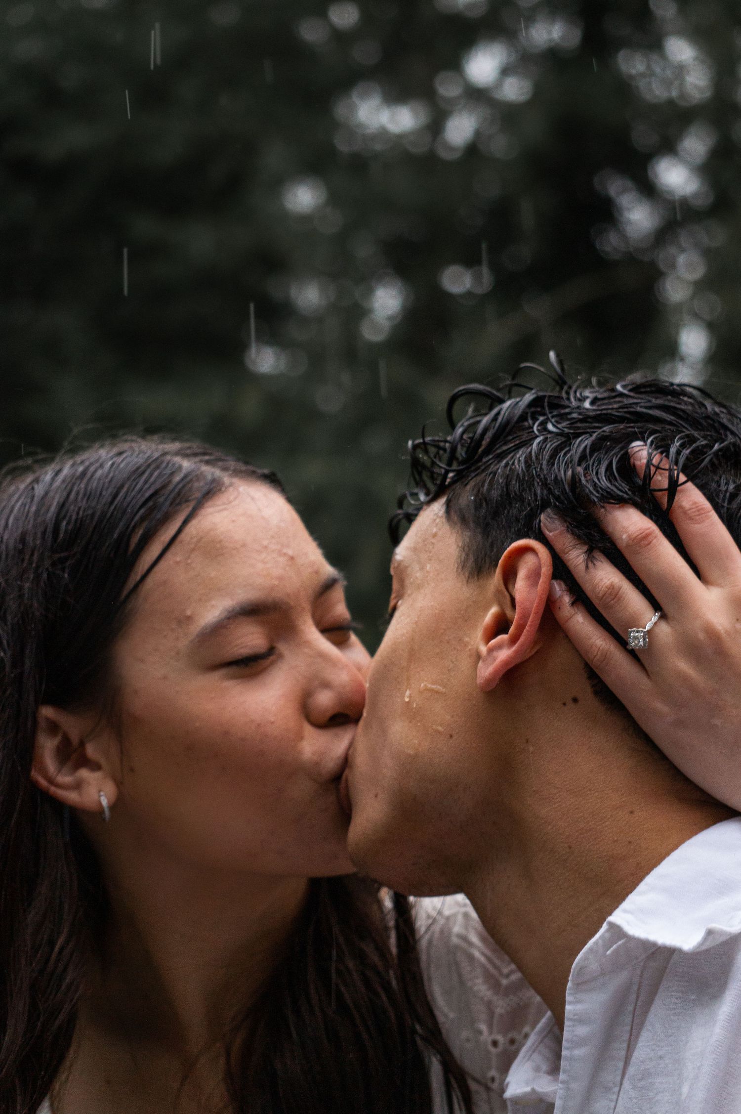 Romantic close-up of couple kissing surrounded by trees during engagement session in Salem OR forest