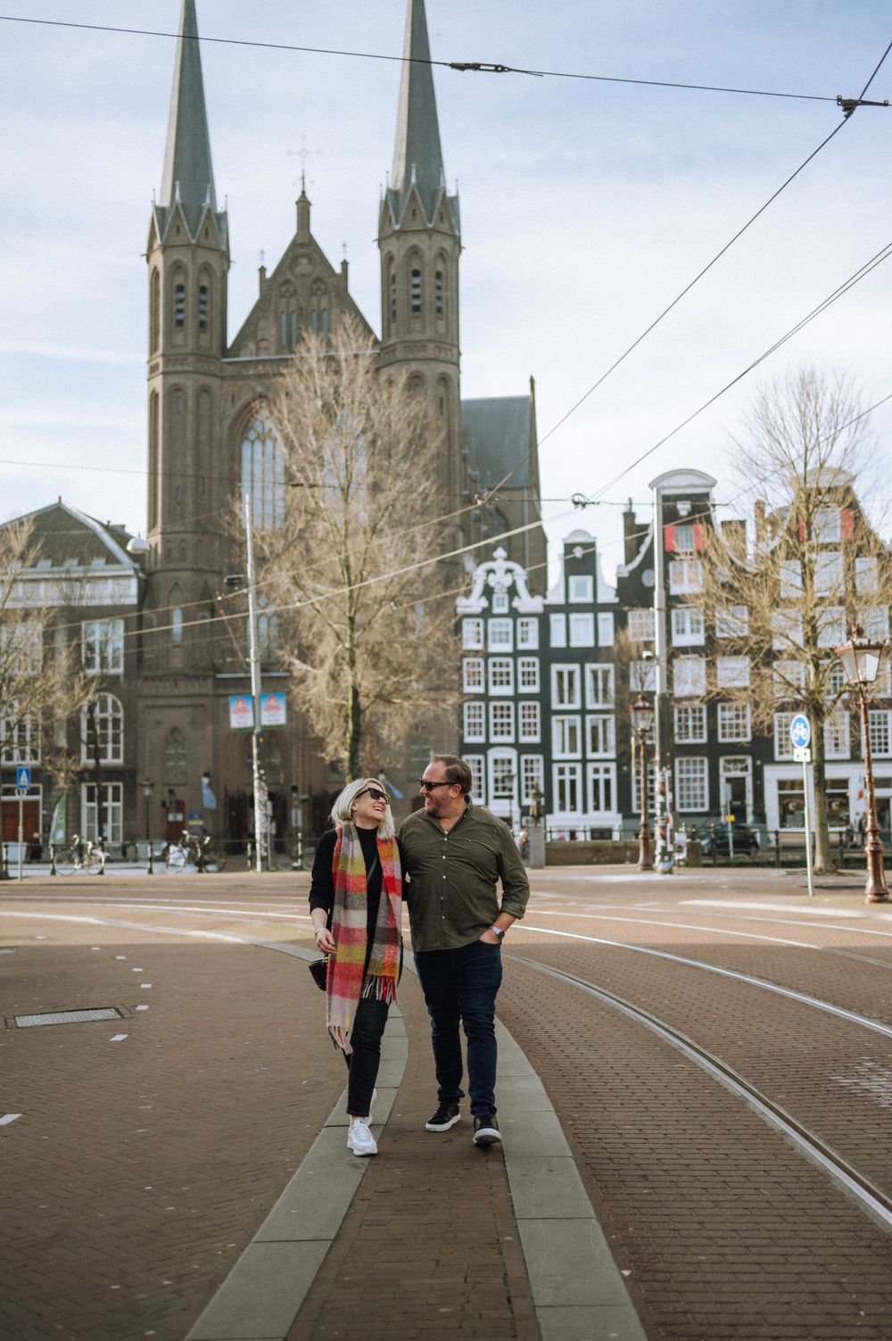 People walking in town square with historic Dutch church and buildings in background.